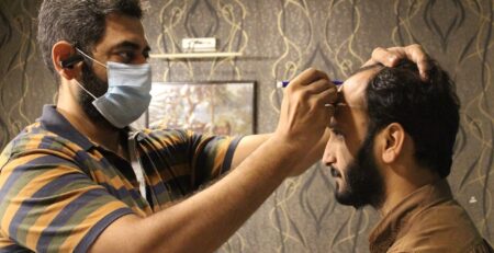 Dr Aneel Riaz is doing hair transplant of a patient
